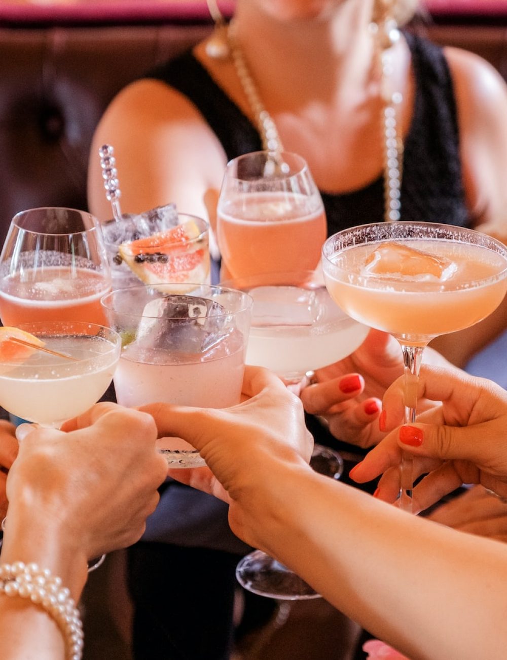 woman in black tank top holding clear wine glass