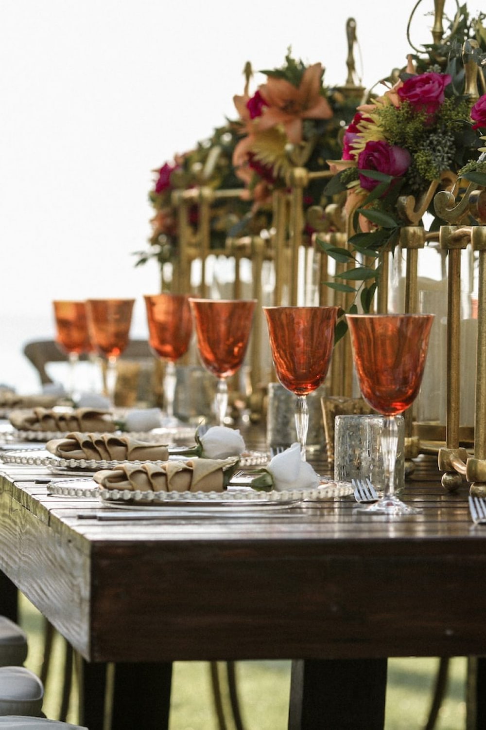 orange tinted wine glasses on rectangular brown wooden dining table